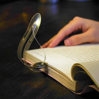 high tech creative design reading lamp illuminating an open book while being held by a hand