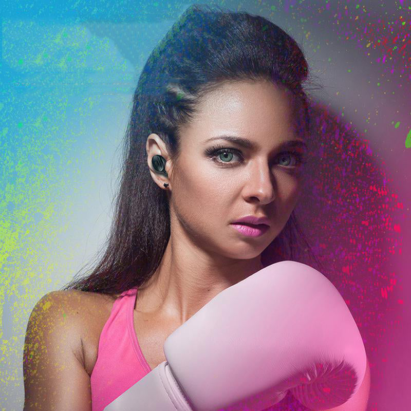 Woman wearing wireless sports headphones for fitness while posing with boxing gloves.